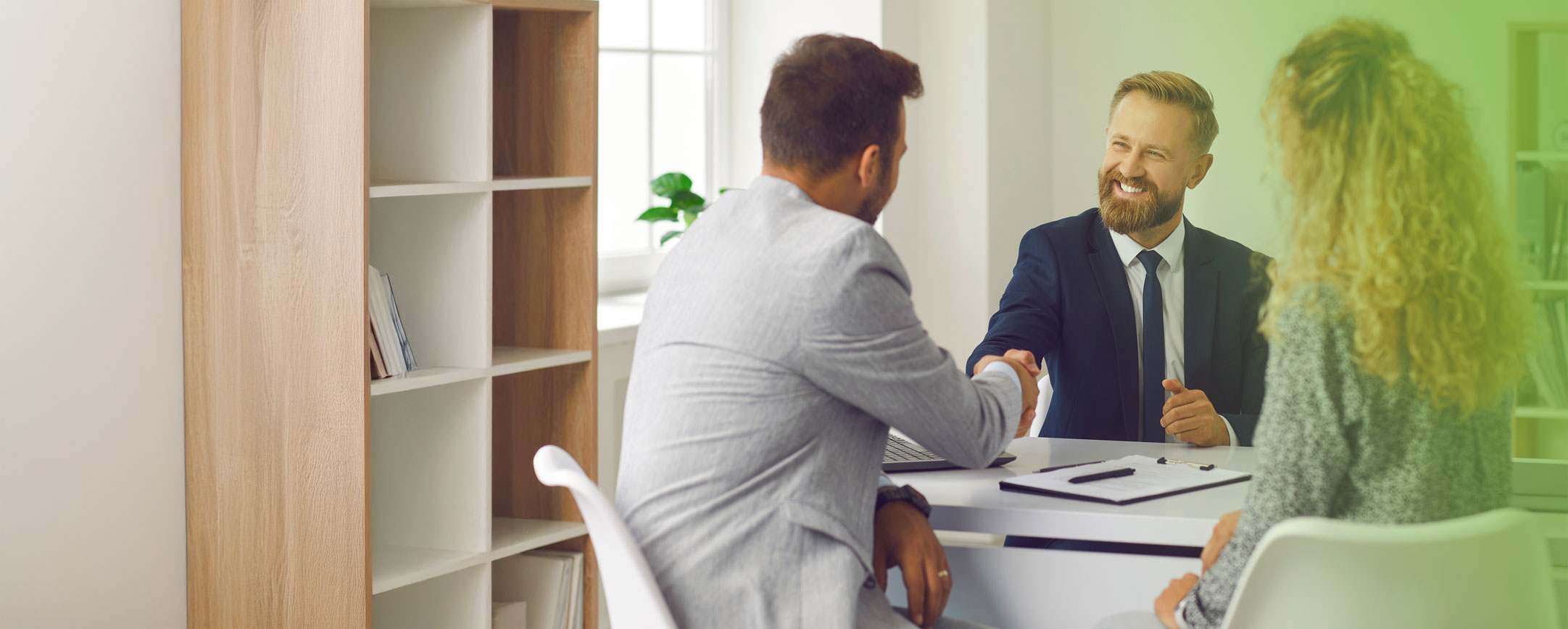 garanzia-di-conformità-banche-finanziarie-società-di-leasing Impiegato bancario stringe mano dei clienti dopo attività di back office, digitalizzazione documenti e garanzia di conformità